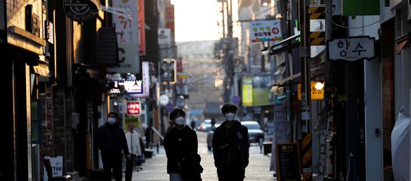 Pedestrians wearing masks amid the rise in confirmed cases of the novel coronavirus disease of COVID-19, make their way at a shopping district in Daegu, South Korea, March 4, 2020 - Sputnik International