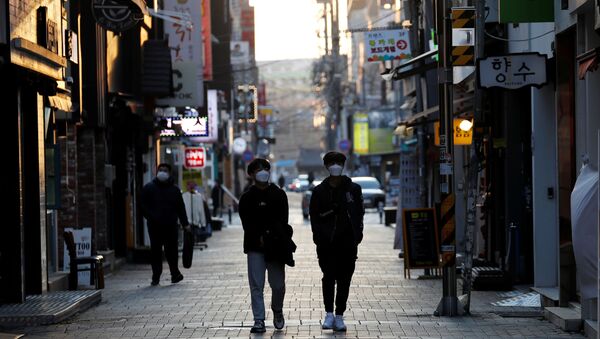 Pedestrians wearing masks amid the rise in confirmed cases of the novel coronavirus disease of COVID-19, make their way at a shopping district in Daegu, South Korea, March 4, 2020 - Sputnik International