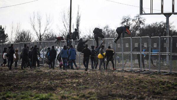 Migrants jump over fences erected by the Turkish army near the Pazarkule border gate in Edirne on March 4, 2020, during their journey to try to enter Europe - Sputnik International