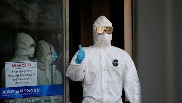 A medical worker gives a thumbs-up to media as he walks out of a facility where coronavirus disease (COVID-19) patients receive treatment at Keimyung University Dongsan Medical Center in Daegu, South Korea, March 5, 2020 - Sputnik International