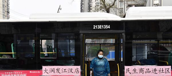 A worker unloads bags of groceries purchased by residents through group orders from a bus in Wuhan, the epicentre of the novel coronavirus outbreak, Hubei province, China March 5, 2020 - Sputnik International