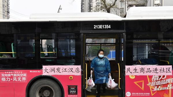 A worker unloads bags of groceries purchased by residents through group orders from a bus in Wuhan, the epicentre of the novel coronavirus outbreak, Hubei province, China March 5, 2020 - Sputnik International