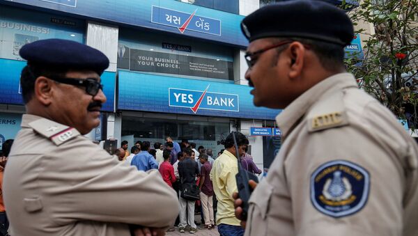 Policemen stand guard as people wait outside a Yes Bank branch to withdraw their money in Ahmedabad, India, March 6, 2020 - Sputnik International
