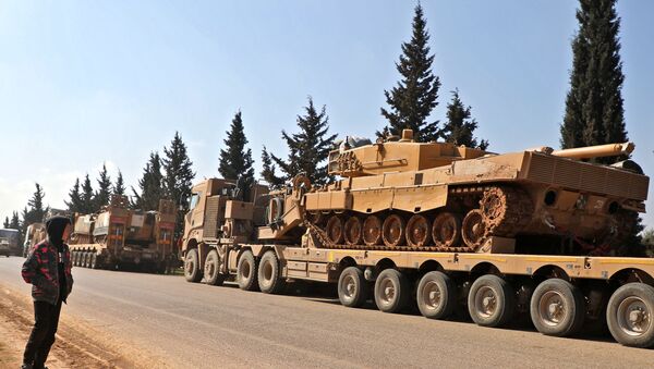 A boy looks at a convoy of Turkish military vehicles near the town of Hazano in the rebel-held northern countryside of Syria's Idlib province on March 3, 2020. - Sputnik International