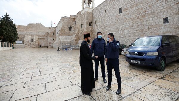 Palestinian police officers stand guard outside the Church of the Nativity that was closed as a preventive measure against the coronavirus, in Bethlehem in theWest Bank March 6, 2020 - Sputnik International