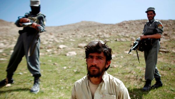 Afghan policemen stand next to a captured Taliban fighter after a gun battle near the village of Shajoy in Zabol province, Afghanistan March 22, 2008. - Sputnik International
