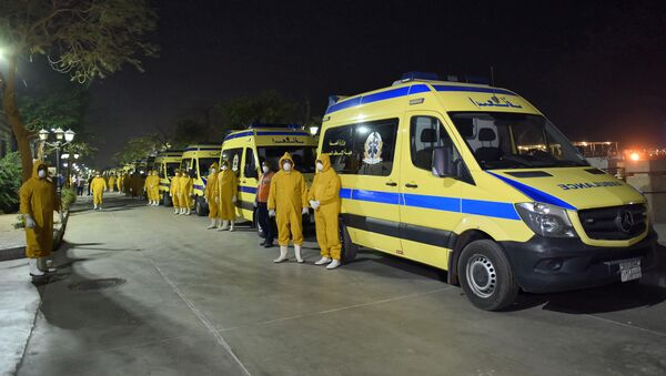 Egyptian health ministry emergency responders stand next to ambulances ready on the scene to transport suspected COVID-19 coronavirus disease cases that were detected on a Nile cruise ship, in the southern city of Luxor late on March 7, 2020.  - Sputnik International