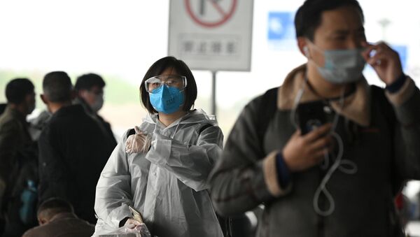 Passengers wearing protective facemasks arrive at the Changsha railway station in Changsha, the capital of Hunan province on March 8, 2020.   - Sputnik International
