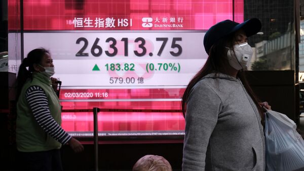 People wear protective masks as they walk past a panel displaying the Hang Seng Index during morning trading following the outbreak of the new coronavirus in Hong Kong, China March 2, 2020 - Sputnik International