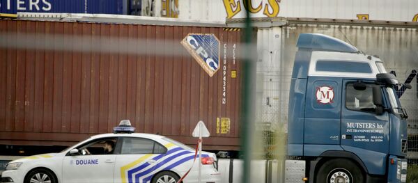 A customs police car parks next to a truck waiting to pass through a scanning tunnel at the Port of Zeebrugge, in Zeebrugge, Belgium, Thursday, Oct. 24, 2019. British police raided two sites in Northern Ireland and questioned a truck driver as they investigate the deaths of 39 people found in a truck container that they believe came from Zeebrugge and was then found at an industrial park in southeastern England. A customs police car parks next to a truck waiting to pass through a scanning tunnel at the Port of Zeebrugge, in Zeebrugge, Belgium, Thursday, Oct. 24, 2019. British police raided two sites in Northern Ireland and questioned a truck driver as they investigate the deaths of 39 people found in a truck container that they believe came from Zeebrugge and was then found at an industrial park in southeastern England. - Sputnik International