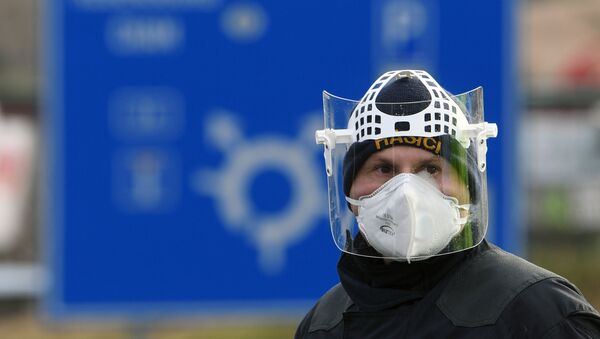 A Czech police officer, with a protective mask, waits during sanitary checks on drivers at the border crossing between Germany and Czech Republic, near the German village of Furth and the Czech village Nova Kubice in a measure to protect against the spread of the novel coronavirus, on March 9, 2020. - Sputnik International