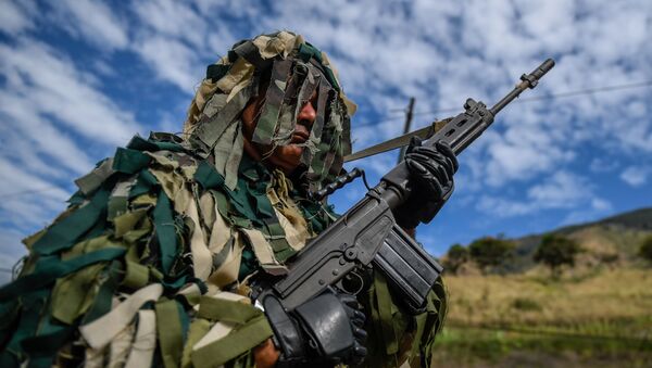 A member of the National Guard takes part in military exercises for the 'Bolivarian Shield 2020 Operation' at Metropolitan distributor in Caracas, on February 15, 2020 - Sputnik International