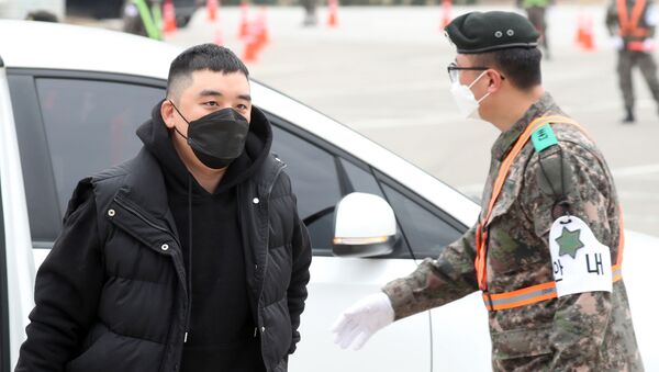 Former BIGBANG boyband member Seungri (L) wearing a face mask arrives at a military boot camp in the border town of Cheorwon, 100 kilometres north of Seoul, on March 9, 2020 - Sputnik International