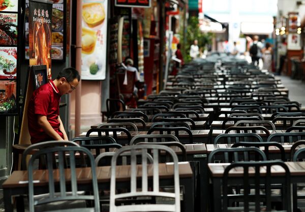 A restaurant promoter waits for customers at the largely empty Chinatown as tourism takes a decline due to the coronavirus outbreak in Singapore February 21, 2020 - Sputnik International