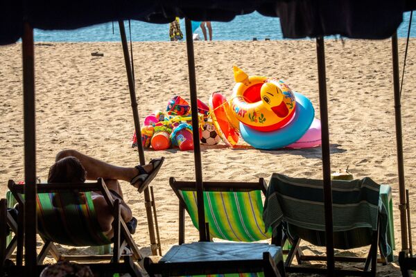 A tourist sits on a sun lounger on an empty beach in Pattaya on March 7, 2020, as visitor numbers in the region have plunged due to the outbreak of the COVID-19 coronavirus - Sputnik International