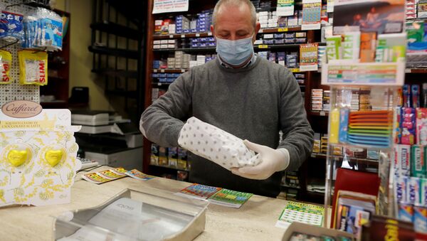A vendor wearing a protective face mask works in a Tobacco Store on the second day of an unprecedented lockdown across all of the country - Sputnik International