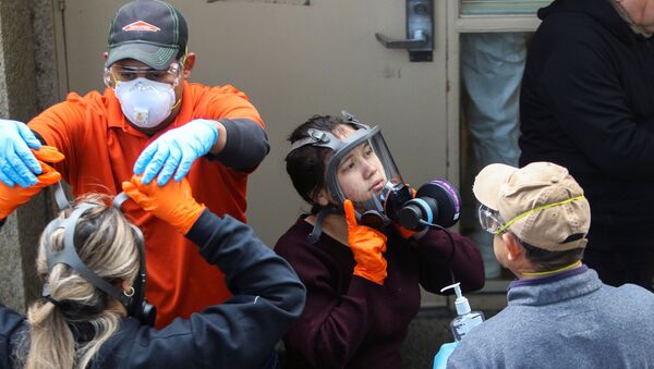 Members of a Servpro cleaning crew take off their protective gears as they exit the Life Care Center of Kirkland, the Seattle-area nursing home at the epicenter of one of the biggest coronavirus outbreaks in the United States, in Kirkland, Washington, U.S. March 11, 2020. - Sputnik International