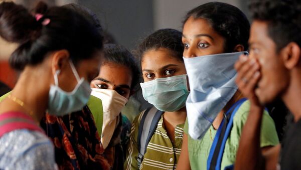 A group of students wearing protective masks wait to buy tickets at a railway station amid coronavirus fears, in Kochi, India, March 10, 2020. - Sputnik International