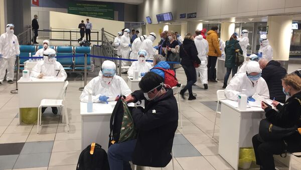 Russian officials and medical staff wearing protective gear check passengers as a preventive measure against the coronavirus (COVID-19) at Moscow's Domodedovo Airport - Sputnik International