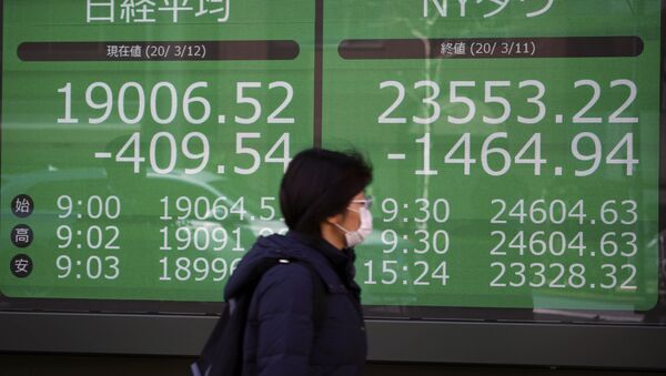 A woman walks past an electronic stock board showing Japan's Nikkei 225 and New York Dow index at a securities firm in Tokyo Thursday, March 12, 2020 - Sputnik International