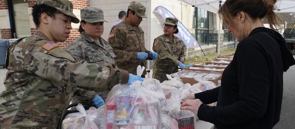 National Guard troops give food to residents of New Rochelle, New York at New Rochelle High School March 12, 2020 - Sputnik International