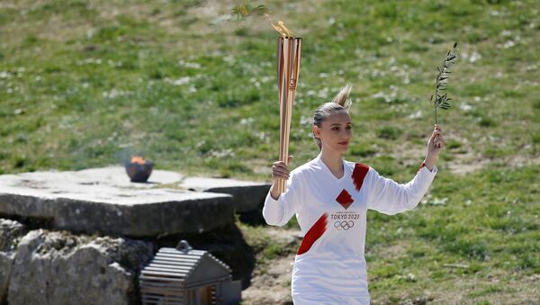 Olympics - Lighting ceremony of the Olympic flame for Tokyo 2020 - Ancient Olympia, Olympia, Greece - March 12, 2020  First torchbearer, Greek shooting athlete Anna Korakaki, carries the Olympic flame and the olive branch during the opening of the Olympic flame torch relay for the Tokyo 2020 Summer Olympics - Sputnik International