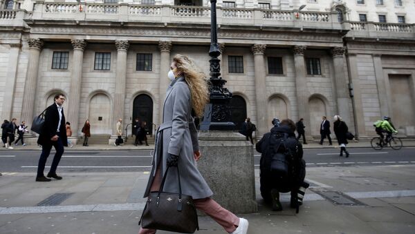 A woman, wearing a protective face mask, walks in front of the Bank of England - Sputnik International
