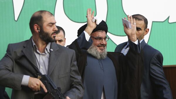 In this Sept 17, 2012 file photo, Hezbollah leader Sheik Hassan Nasrallah, center, escorted by his bodyguards, waves to a crowd of tens of thousands of supporters during a rally denouncing an anti-Islam film that has provoked a week of unrest in Muslim countries worldwide, in a southern suburb of Beirut, Lebanon. - Sputnik International