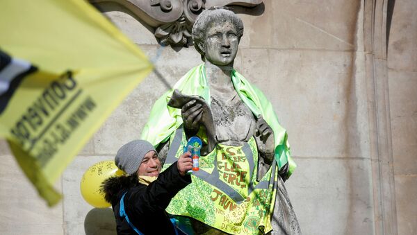 A protester stands next to a statue dressed in a yellow vest in front of the Opera Garnier during a demonstration before the opening debate on the French government's pensions reform bill at the National Assembly in Paris, France, 17 February 2020.  - Sputnik International