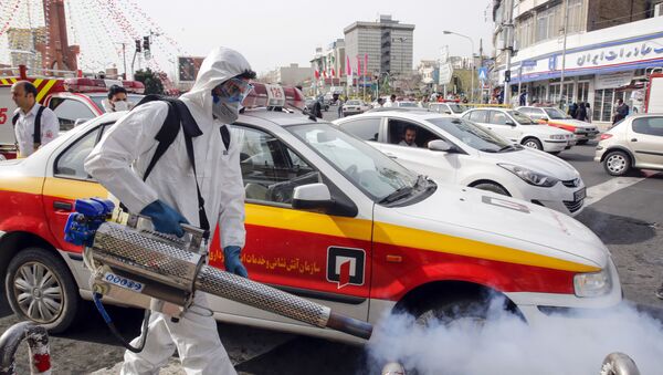 An Iranian firefighter disinfects a street in the capital Tehran in a bid to halt the wild spread of coronavirus on March 13 2020. - Iranian forces will clear the streets nationwide within 24 hours and all citizens will be checked for the new coronavirus in a bid to halt its spread, the military said - Sputnik International