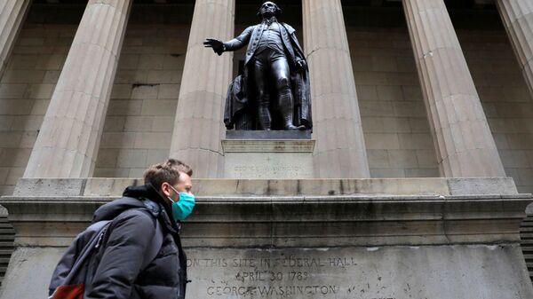 A man in a surgical mask walks in front of a statue of first US President George Washington - Sputnik International