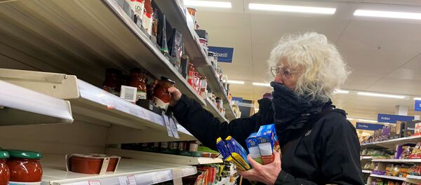 A shopper covers her face at a supermarket, as the number of coronavirus cases grow around the world, in London, Britain March 15, 2020. A shopper covers her face at a supermarket, as the number of coronavirus cases grow around the world, in London, Britain March 15, 2020. - Sputnik International