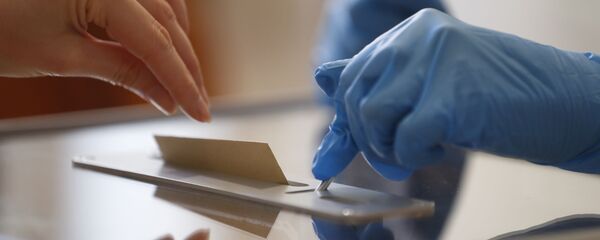 A voting volunteer using gloves opens the voting box for a vote during the first round of the municipal elections, in Strasbourg, eastern France, Sunday March 15, 2020. France is holding nationwide elections Sunday to choose all of its mayors and other local leaders despite a crackdown on public gatherings because of the new virus. For most people, the new coronavirus causes only mild or moderate symptoms. For some it can cause more severe illness.  - Sputnik International