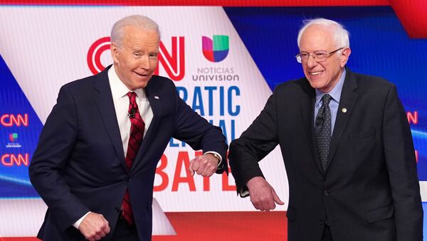 Democratic U.S. presidential candidates former Vice President Joe Biden and Senator Bernie Sanders do an elbow bump in place of a handshake as they greet other before the start of the 11th Democratic candidates debate of the 2020 U.S. presidential campaign, held in CNN's Washington studios without an audience because of the global coronavirus pandemic, in Washington, U.S. March 15, 2020. - Sputnik International