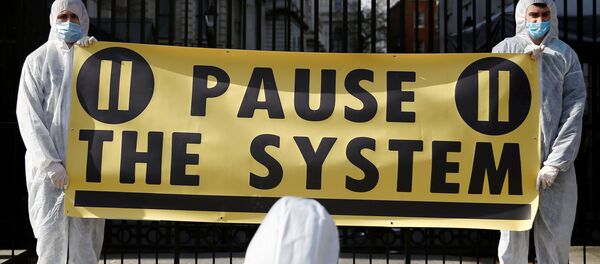 Protesters from organization Pause the System wearing hazmat suits demonstrate against government's response to the coronavirus crisis, outside Downing Street in London, Britain March 16, 2020. REUTERS/Henry Nicholls - Sputnik International