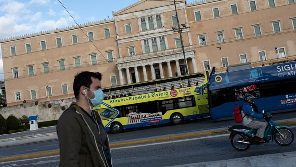 A man wearing a protective face mask walks past the parliament building in Athens, Greece - Sputnik International