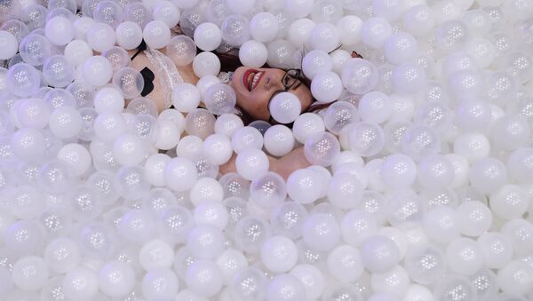 Web cam model Sammy Strips lies in a tub of plastic balls at the Cam4 booth during the AVN Adult Entertainment Expo, Wednesday, Jan. 24, 2018, in Las Vegas - Sputnik International