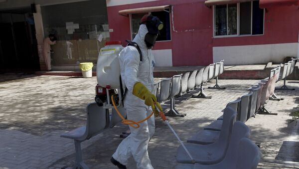 A worker wearing protective gear sprays disinfectant as a precaution against the new coronavirus, at the Pakistan Institute of Medical Sciences Hospital, in Islamabad, Pakistan, Tuesday, March 17, 2020.  - Sputnik International