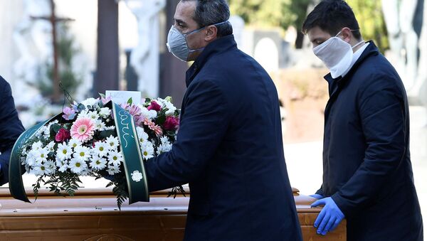 Cemetery workers and funeral agency workers in protective masks transport a coffin of a person who died from coronavirus disease (COVID-19), into a cemetery in Bergamo, Italy March 16, 2020 - Sputnik International