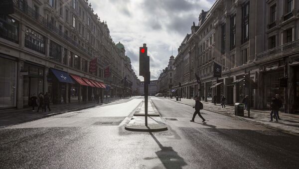 A man crosses a deserted Regent Street - usually one of London's busiest thoroughfares - Sputnik International