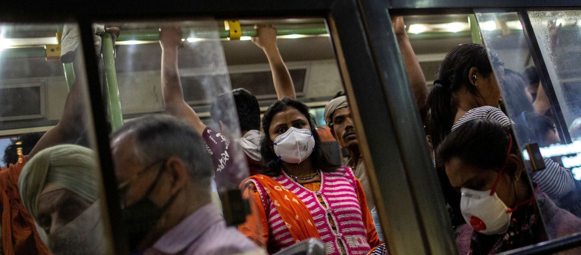 Commuters wearing protective masks as a precaution against the spread of coronavirus disease (COVID-19), travel in a crowded bus during evening rush hour, in New Delhi, India, March 18, 2020.  - Sputnik International, 1920, 26.03.2020