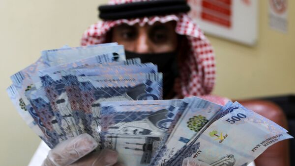 A Saudi money exchanger wears gloves as he counts Saudi riyal currency at a currency exchange shop in Riyadh, Saudi Arabia March 10, 2020 - Sputnik International
