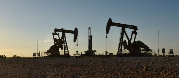 Pump jacks operate in front of a drilling rig in an oil field in Midland, Texas U.S. August 22, 2018. Picture taken August 22, 2018. Pump jacks operate in front of a drilling rig in an oil field in Midland, Texas U.S. August 22, 2018. Picture taken August 22, 2018. - Sputnik International