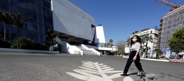 A woman wearing a protective face mask near the Festival palace on the Croisette in Cannes A woman wearing a protective face mask near the Festival palace on the Croisette in Cannes - Sputnik International