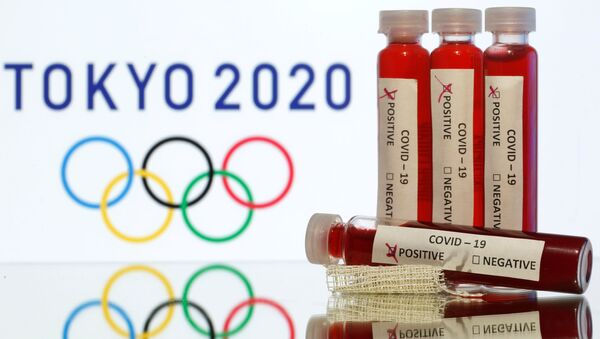 Fake blood in seen in test tubes labelled with coronavirus disease (COVID-19) in front of a displayed Tokyo 2020 Olympics logo in this illustration taken March 19, 2020 - Sputnik International