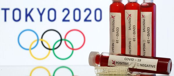 Fake blood in seen in test tubes labelled with coronavirus disease (COVID-19) in front of a displayed Tokyo 2020 Olympics logo in this illustration taken March 19, 2020 - Sputnik International