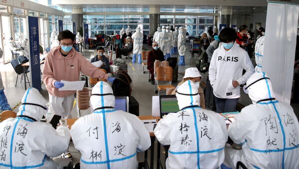 Passengers register their information at the New China International Exhibition Center, a transit hub to screen incoming passengers from the Beijing Capital International Airport for COVID-19, caused by the coronavirus, in Beijing, China March 18, 2020. Picture taken March 18, 2020 - Sputnik International