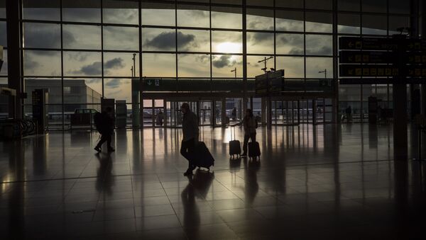 Passengers walk in an empty terminal at the airport of Barcelona, Spain, Thursday, March 19, 2020 - Sputnik International