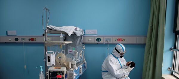 A nurse in protective suit attends to a baby with COVID-19, caused by the coronavirus, at an isolation ward of Wuhan Children's Hospital in Wuhan, Hubei province, China March 16, 2020 - Sputnik International