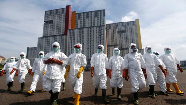 Indonesian Red Cross Society personnel walk in protective suits during an operation to spray disinfectant at the Kemayoran Athletes Village, to prevent the spread of coronavirus disease (COVID-19) in Jakarta, Indonesia, March 21, 2020.  - Sputnik International